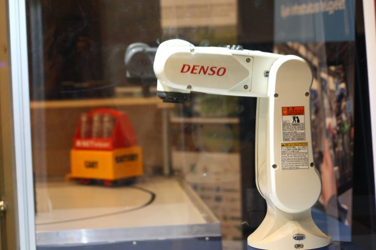 Ipari robot
Az adatgyűjtés és optimalizáció mellett az automatizáció az Ipar 4.0 kulcs eleme. A Delta Robotics által forgalmazott DENSO ipari robot, amely megtekinthető a TK-ban, egy kifejezetten ipari környezetre tervezett, nagy sebességgel és pontossággal működő kooperatív ipari robot. A robot védett géptérben működik, por-, füst-, tűz-, pára-, és vízvédelemmel is el van látva. A szcenárió részeként egy ragasztó adagoló fejjel műküdik, a demonstráció kedvéért a valós sebességének körülbelül 20%-val.
Együttműködő partner: Delta Robotics